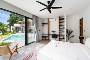 Enjoy the pool view from this second bedroom featuring a workspace desk, safety deposit box, and ample wardrobe space