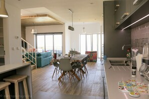 Open plan kitchen, dining and living with picture windows to the ocean & balco
